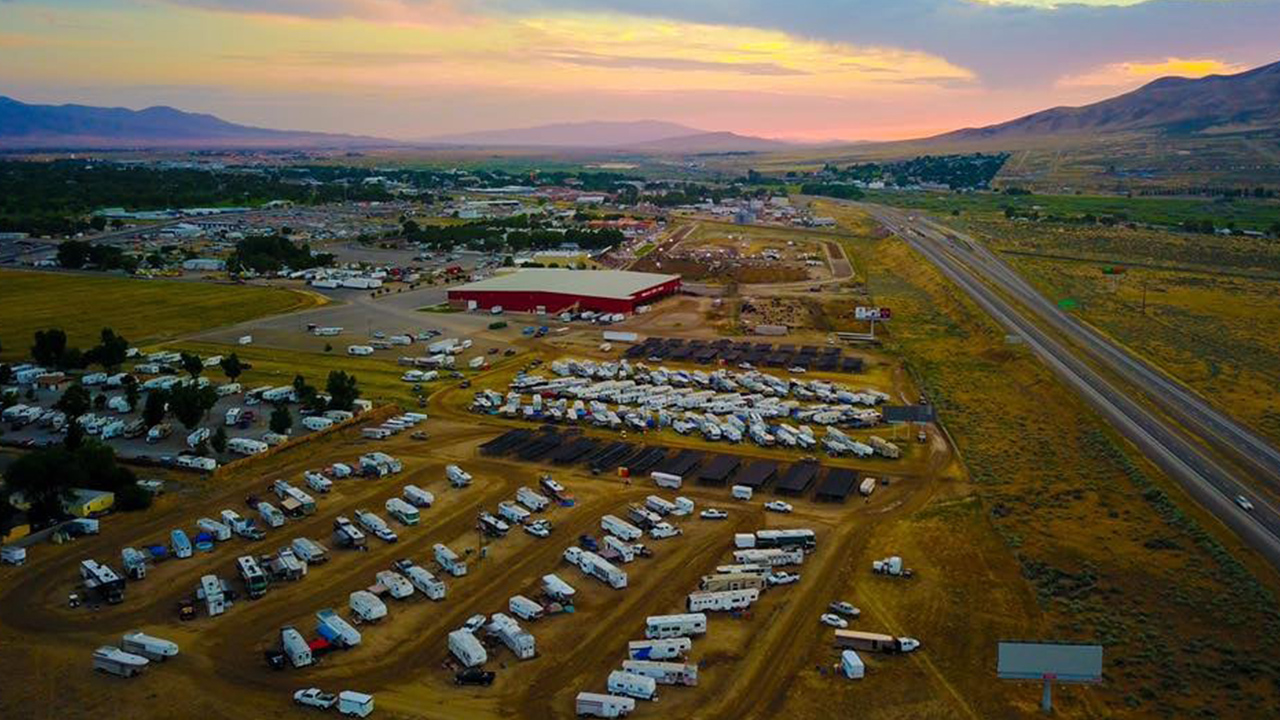 Wide shot of the Winnemucca Events Center and parking lot filled with cars