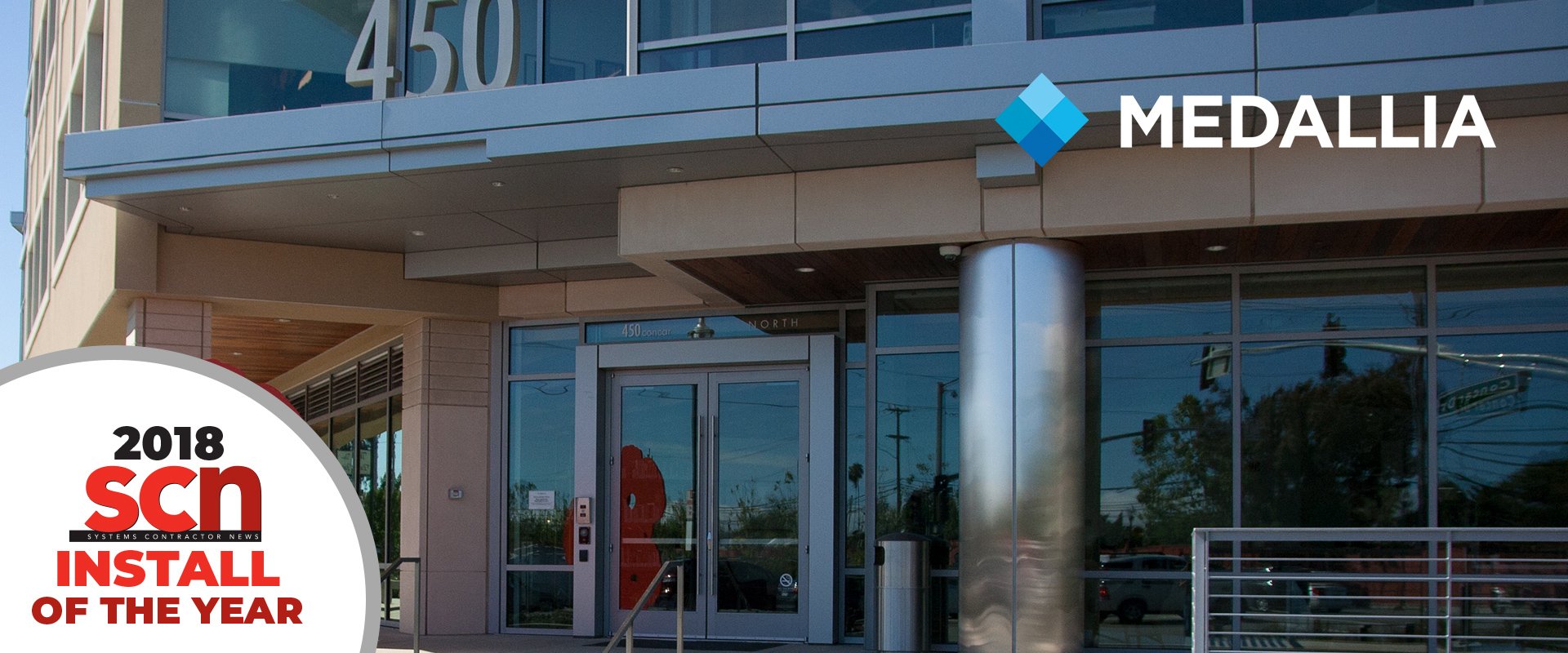 Entrance of a building with a 2018 SCN Install of the year badge and Medallia logo