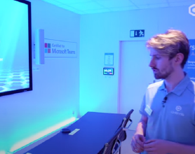 Video thumbnail of a man inspecting a Microsoft Teams Signature Room featuring Q-SYS peripherials