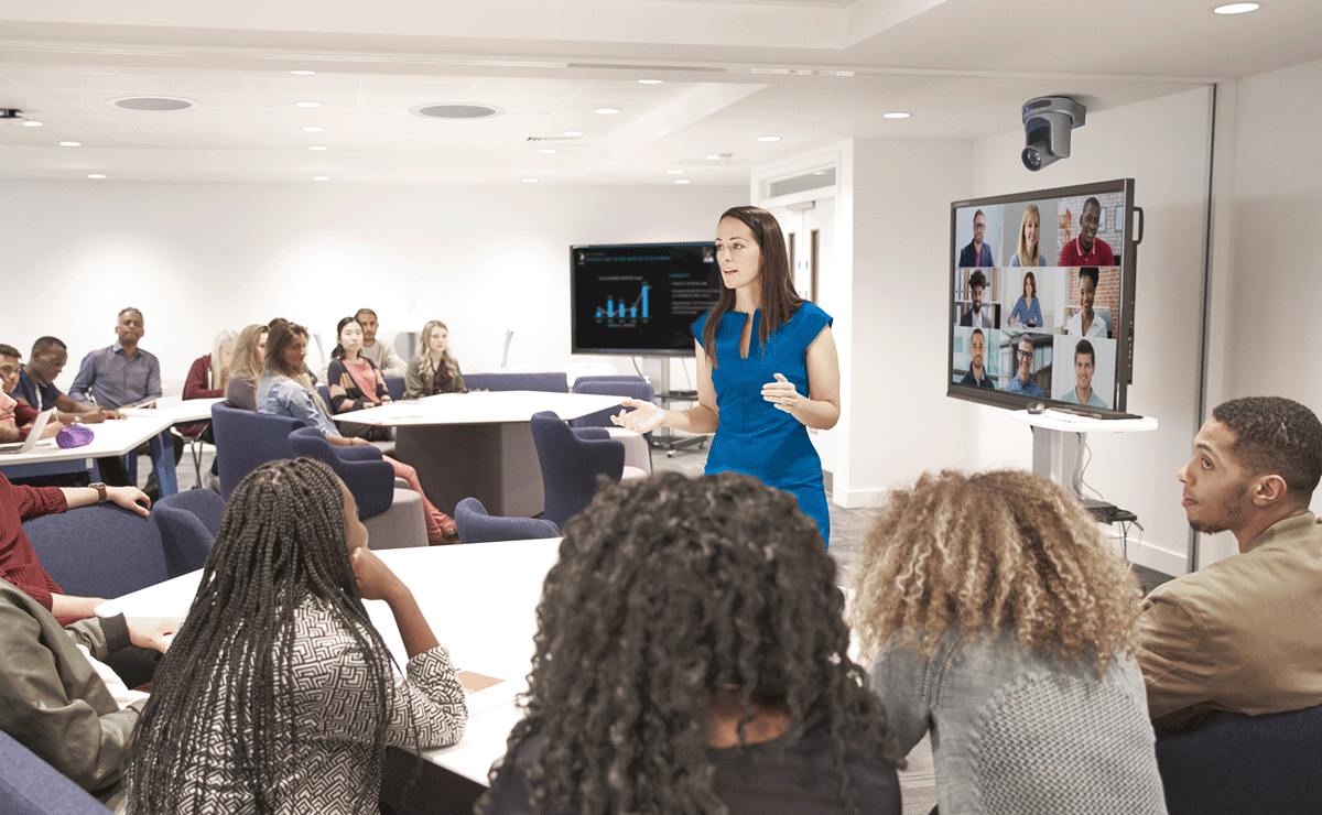 Image of woman speaking to people in a conference room