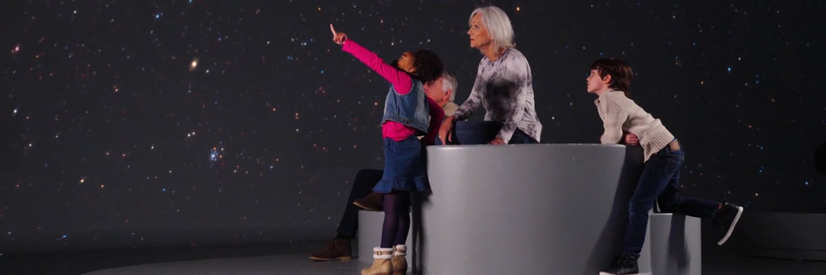 A family inside of Illuminarium's planetarium