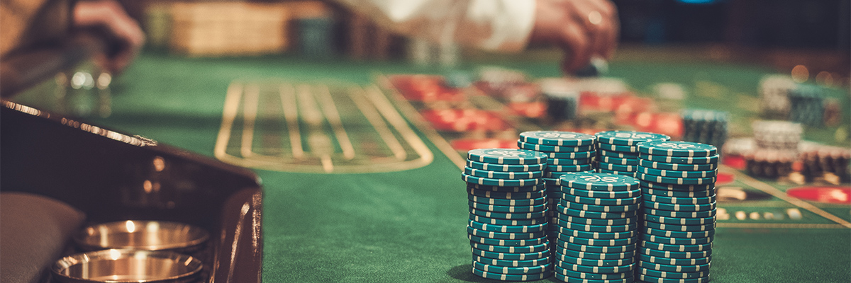 Closeup of a large stack of green casino chips on a roulette table