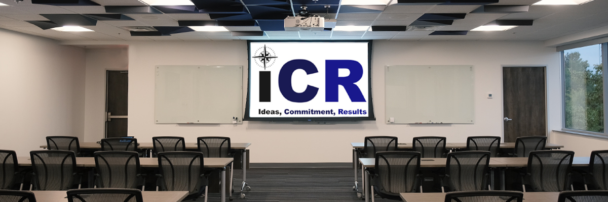 An empty training room at the iCR headquarters with the iCR logo on a projector screen