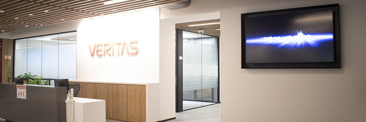 The Veritas receiption desk with a brightly lit logo and a display